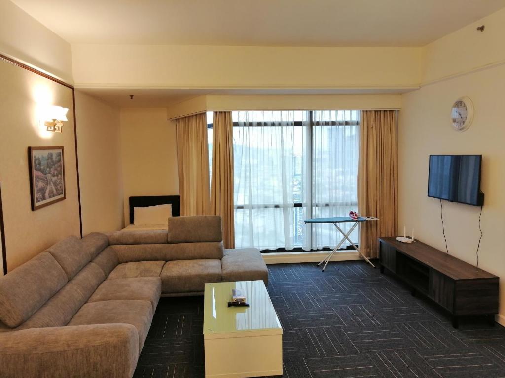 a living room with a couch and a flat screen tv at Kl Raymond Apartment At Time's Square in Kuala Lumpur