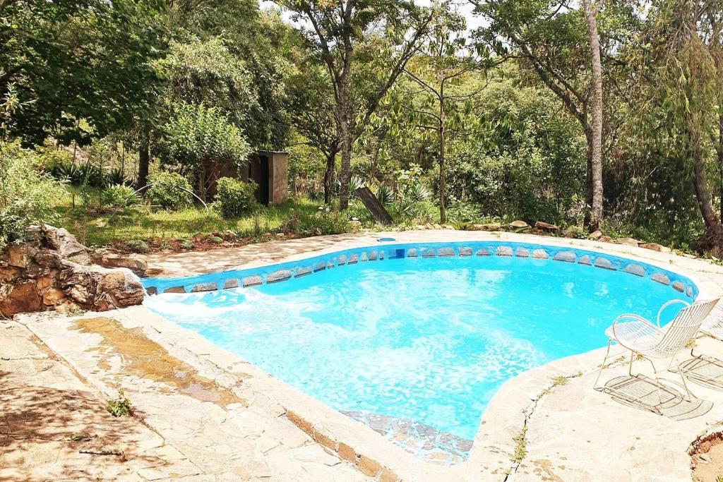 - une piscine avec une chaise, une table et des chaises dans l'établissement Remarkable 3-Bed Cottage in Nyanga, à Juliasdale