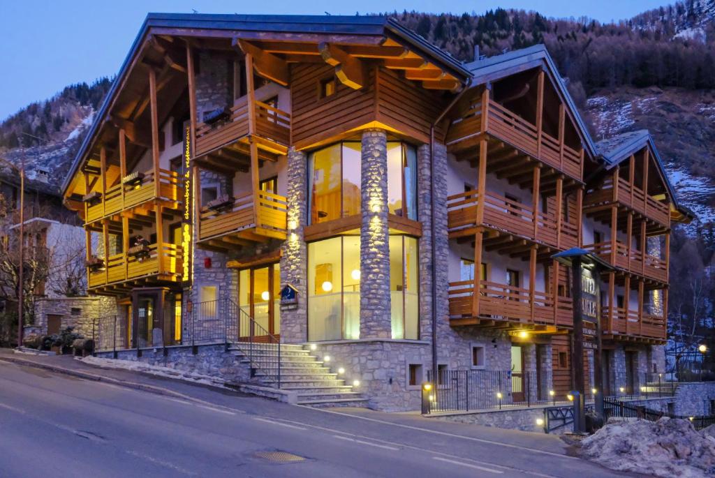 una grande casa in legno sul lato di una strada di Hotel Aigle a Courmayeur