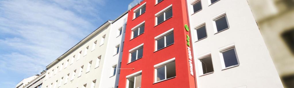 uma fachada vermelha de um edifício com o céu ao fundo em Smart Apart Living - Wien Hauptbahnhof - self check-in em Viena