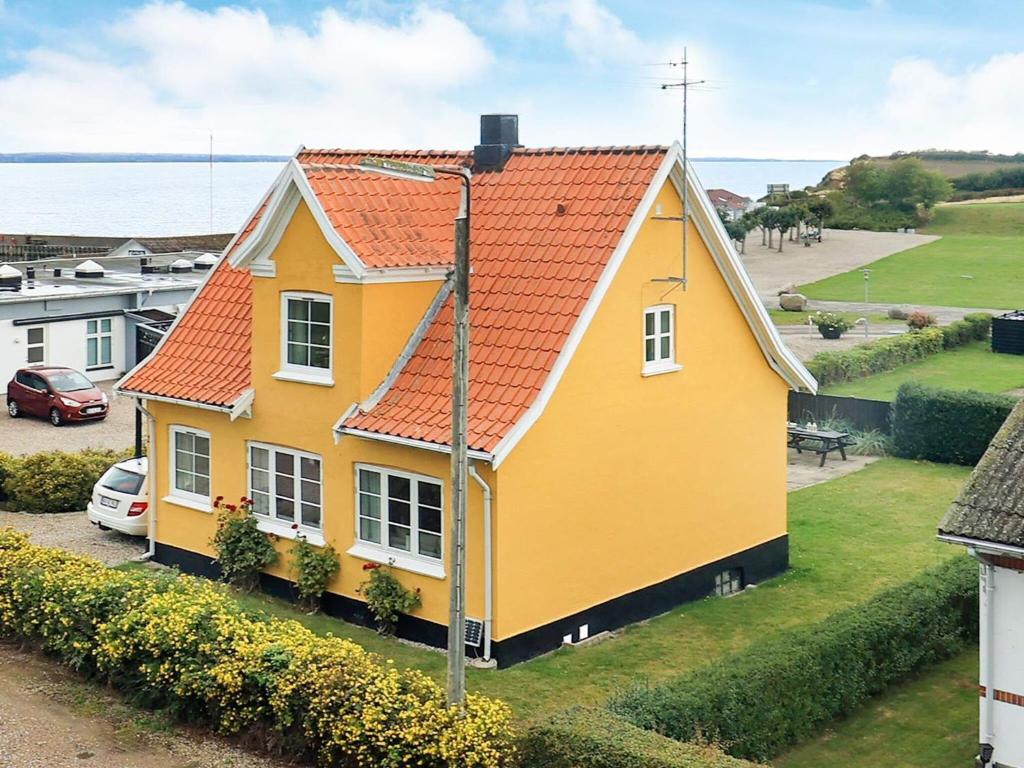 una casa amarilla con techo naranja en 6 person holiday home in Tranek r, en Tranekær