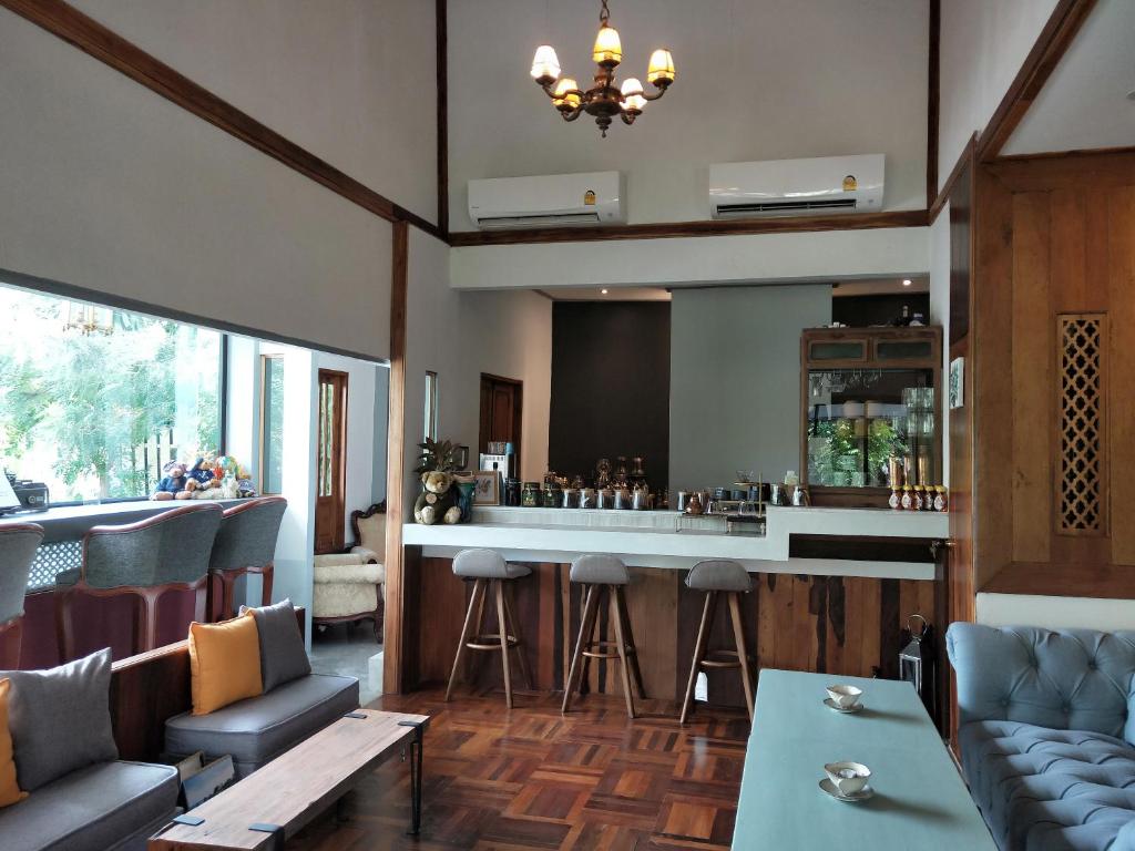un bar dans un restaurant avec des chaises et un comptoir dans l'établissement Reun Sroyraya Boutique Home เรือนสร้อยระย้าบูทิค, à Ban Kok Sai