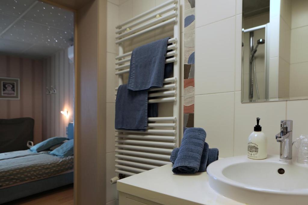 a bathroom with a sink and a mirror and a bed at A Casa in Nieuwpoort