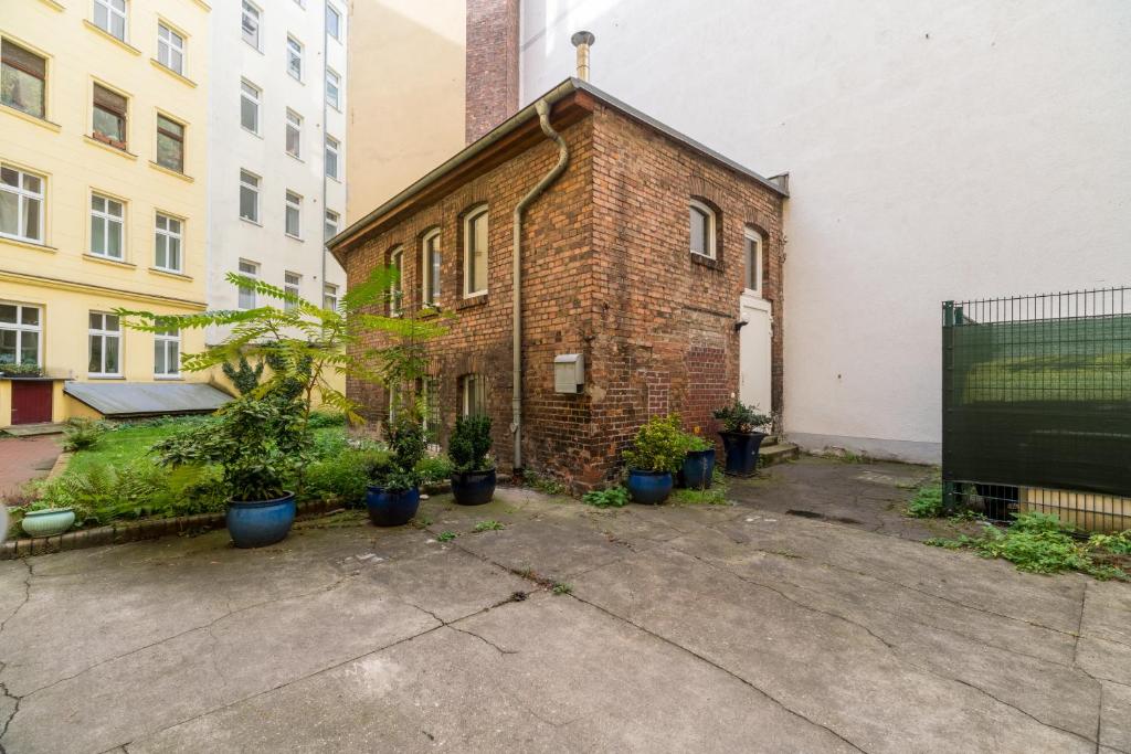 a brick building with potted plants in front of it at Urban Duplex in Berlin