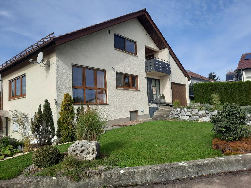 a large white house with a yard with a yard at Ferienwohnung Schwäbische Alb in Justingen