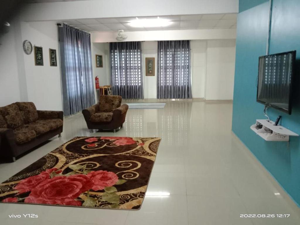 - un salon avec deux chaises et un tapis dans l'établissement Rizqy Homestay di Jitra, à Jitra