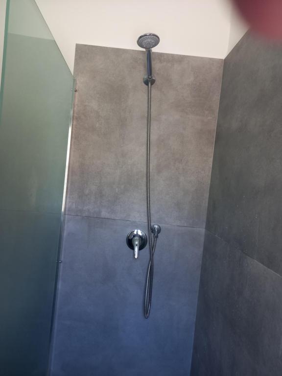 a shower with a shower head on a wall at Balcone delle mura in Cefalù