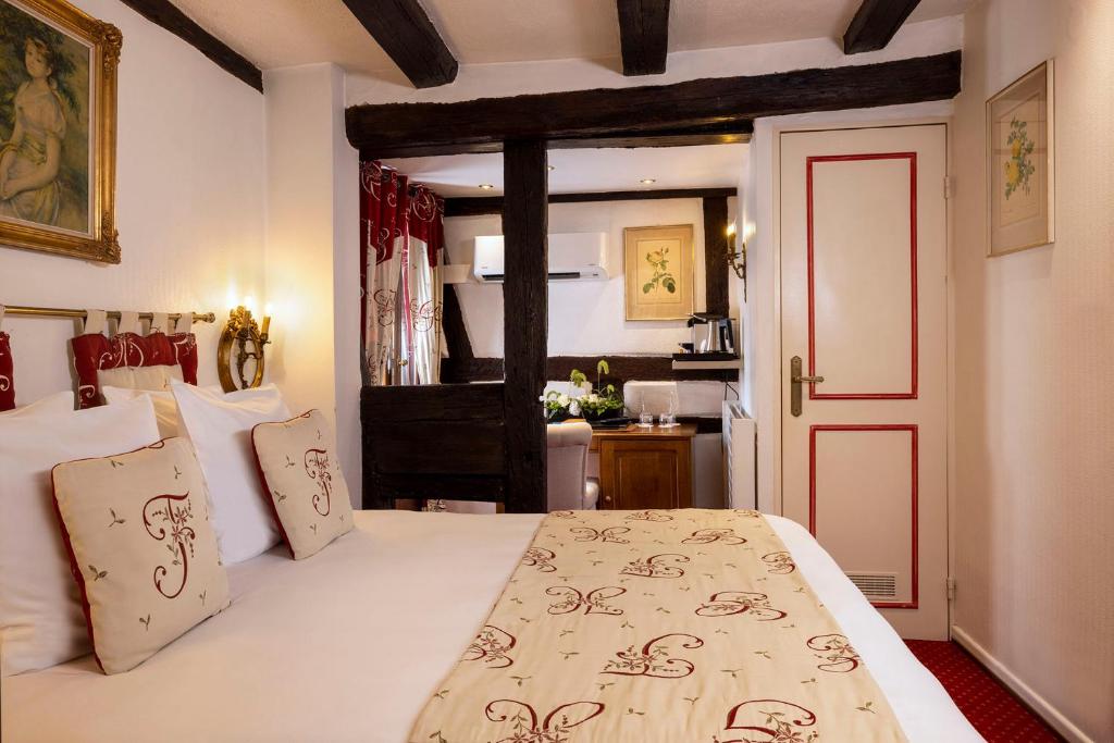 a bedroom with a large bed and a bathroom at Hotel Restaurant Le Maréchal - Teritoria in Colmar