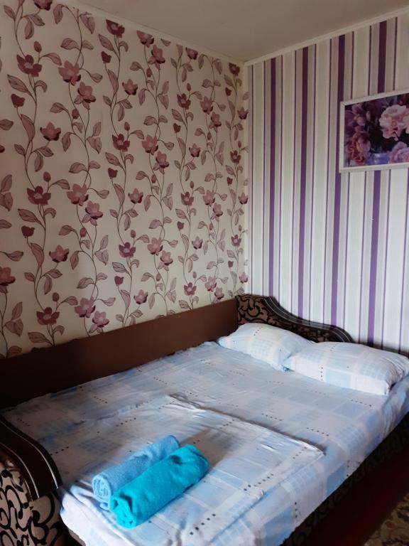 a bed in a room with a wall with flowers at Чорних Запорожців 17, інститут серця in Kyiv