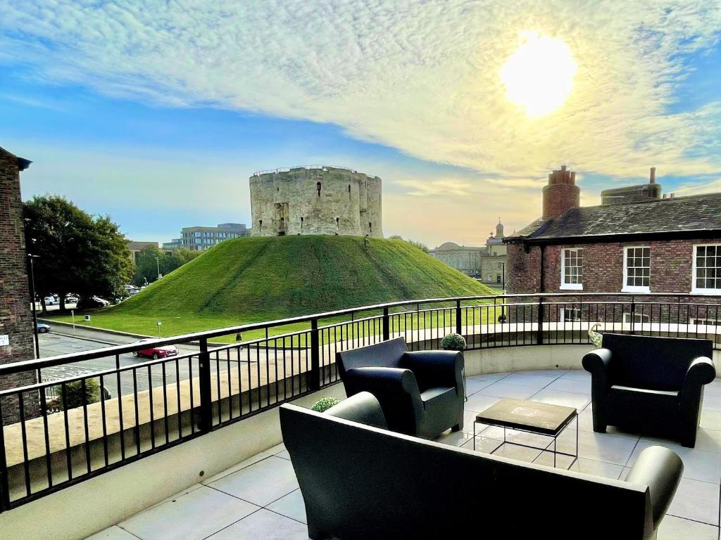 a balcony with chairs and a view of a castle at The Old Fire Station Luxury Apartment in York