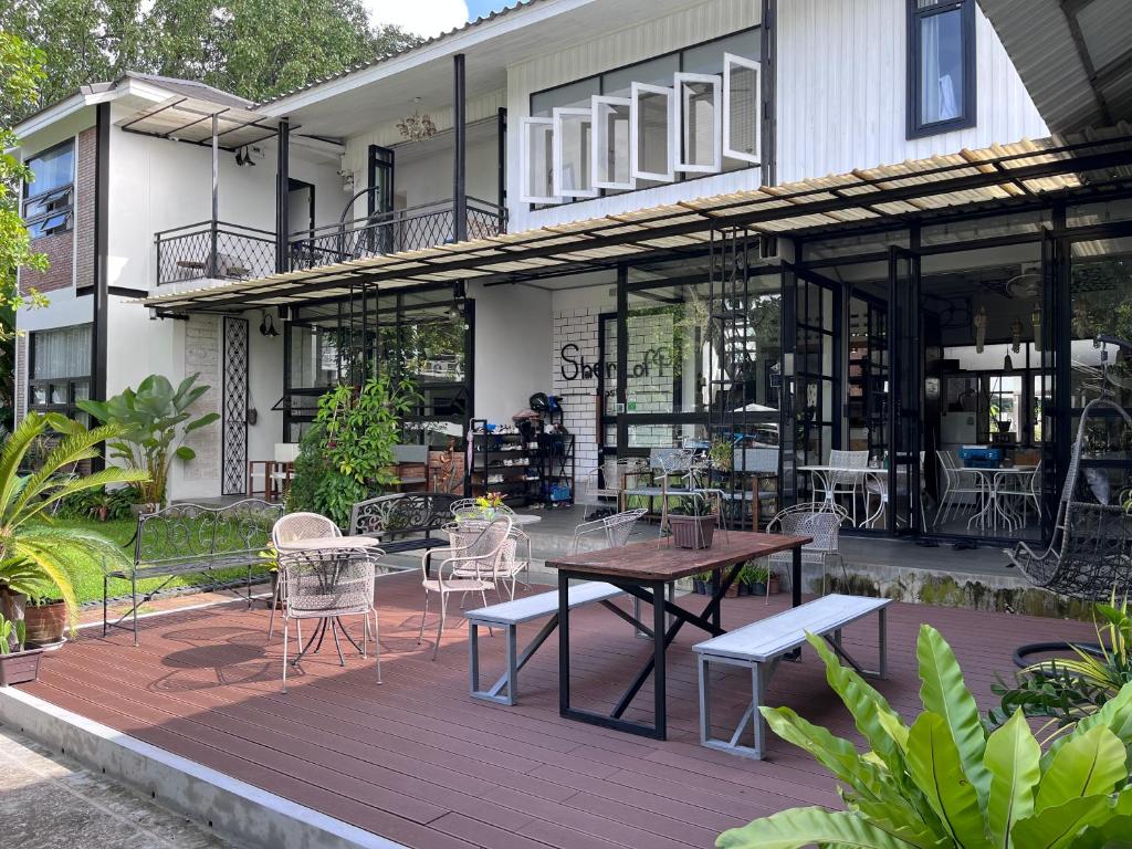 a patio with a table and chairs in front of a building at Sherloft Home & Hostel in Chiang Mai