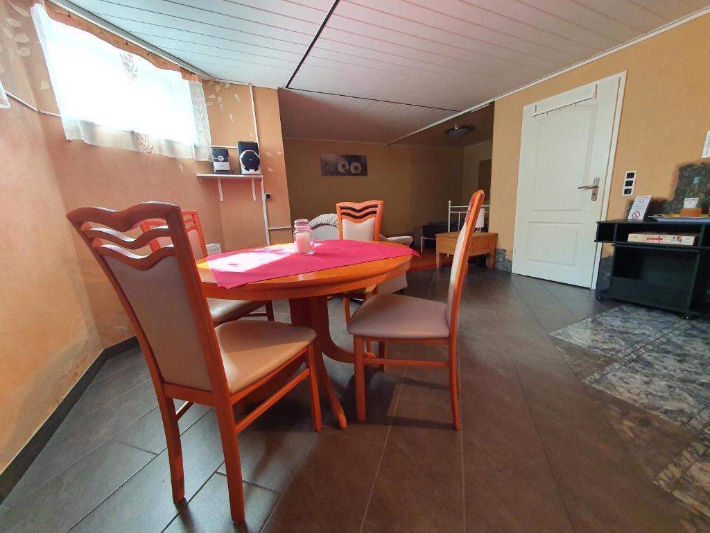 een eettafel met stoelen en een roze tafelkleed bij Ferienwohnung in der Siedlung in Klinga