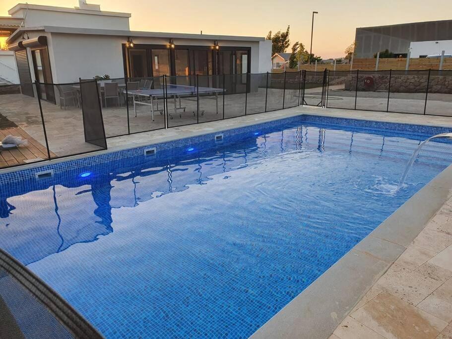 una piscina de agua azul frente a una casa en זריחה למרגלות הגלבוע, en Nurit