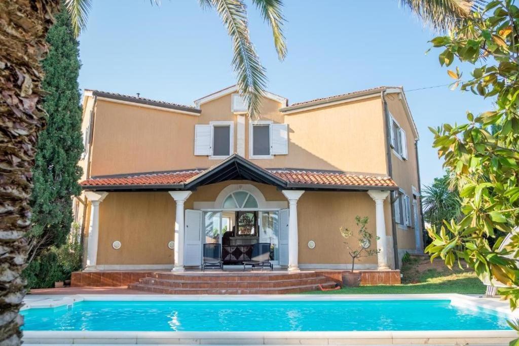 een huis met een zwembad ervoor bij Villa Alberi with pool in Savudrija