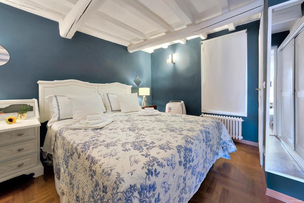 a bedroom with a bed and a blue wall at Santo Spirito Romantic in Florence