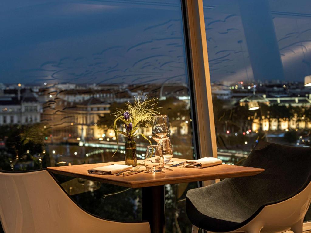 una mesa con vistas a la ciudad por la noche en Sofitel Lyon Bellecour, en Lyon