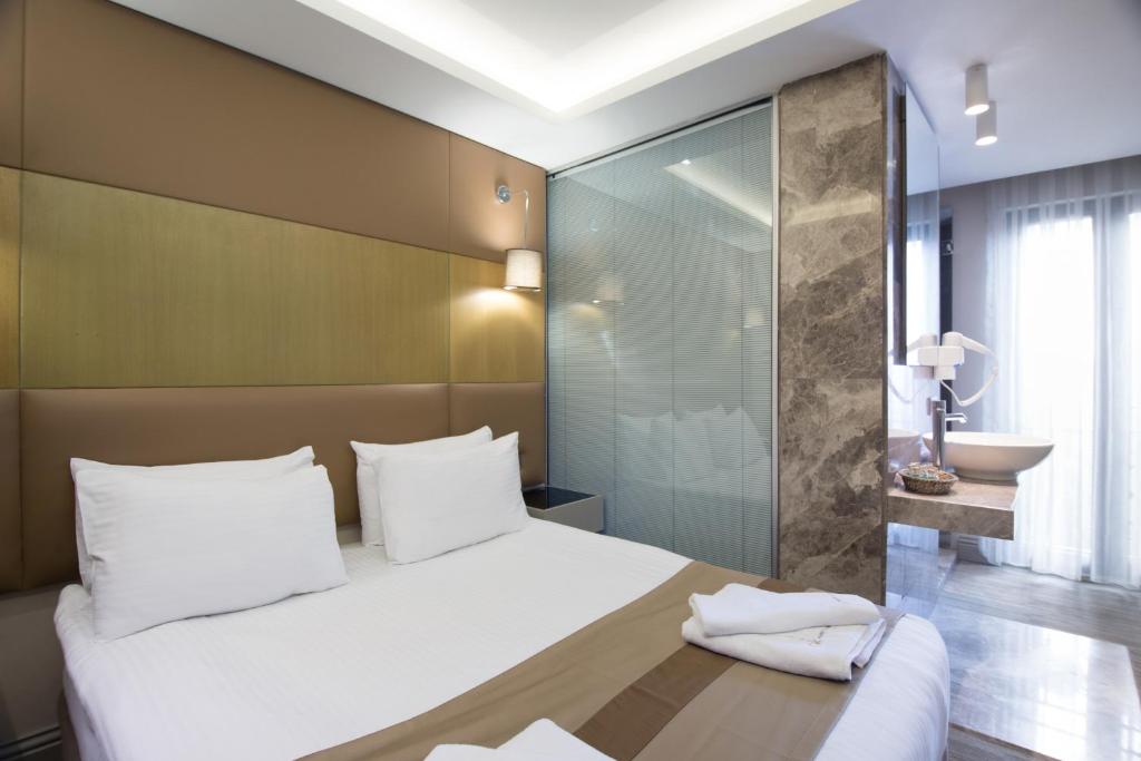 Postel nebo postele na pokoji v ubytování GK Regency Suites Hotel
