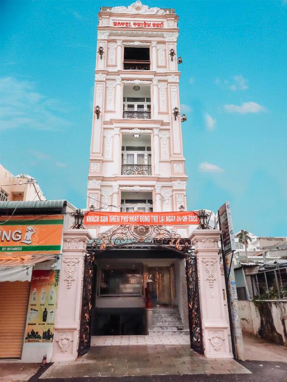 a tall white building with a clock tower at thiên phú hotel in Ho Chi Minh City