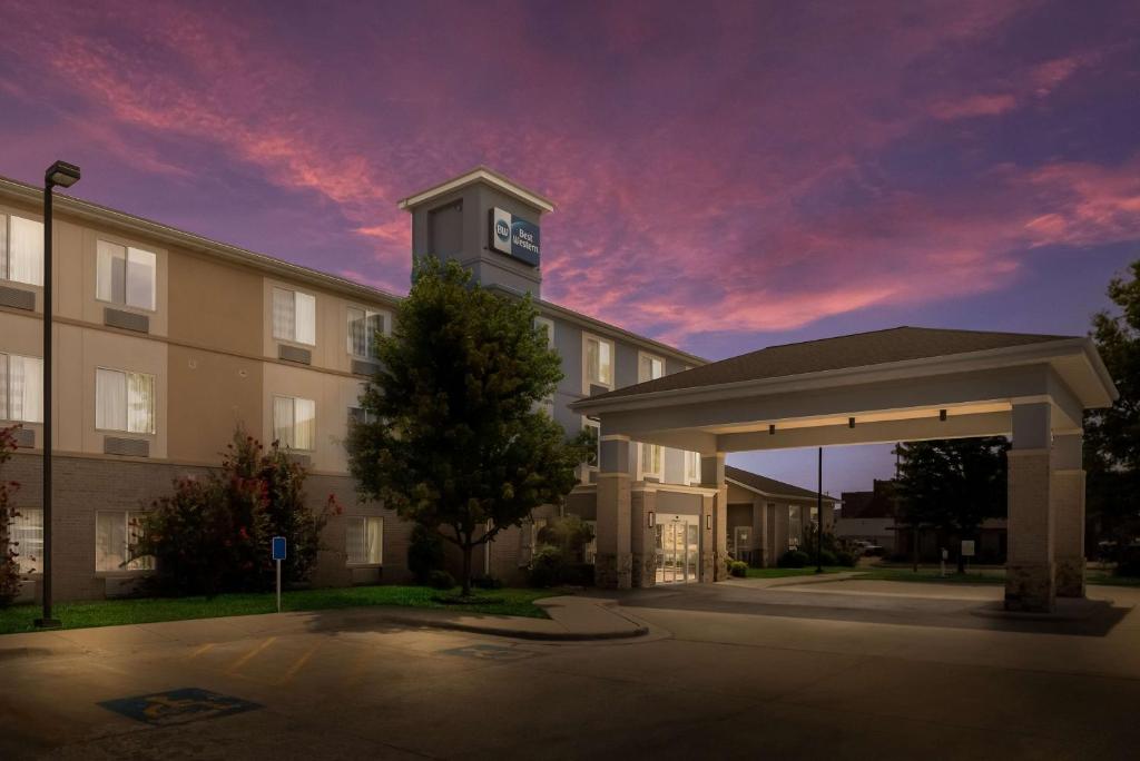 a building with a clock tower in a parking lot at Best Western Coffeyville Central Business District Inn and Suites in Coffeyville