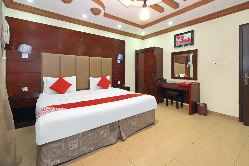 - une chambre avec un grand lit et un bureau dans l'établissement OYO 589 Lavina House, à Djeddah