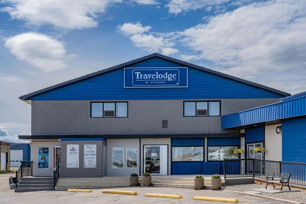 duży niebieski budynek z napisem w obiekcie Travelodge by Wyndham Fort St John w mieście Fort St. John