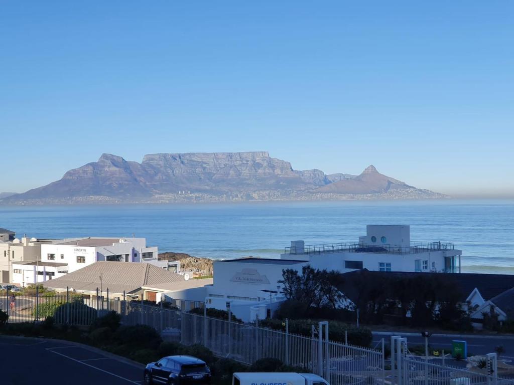 a view of the ocean with a mountain in the background at Blouberg heights in Cape Town