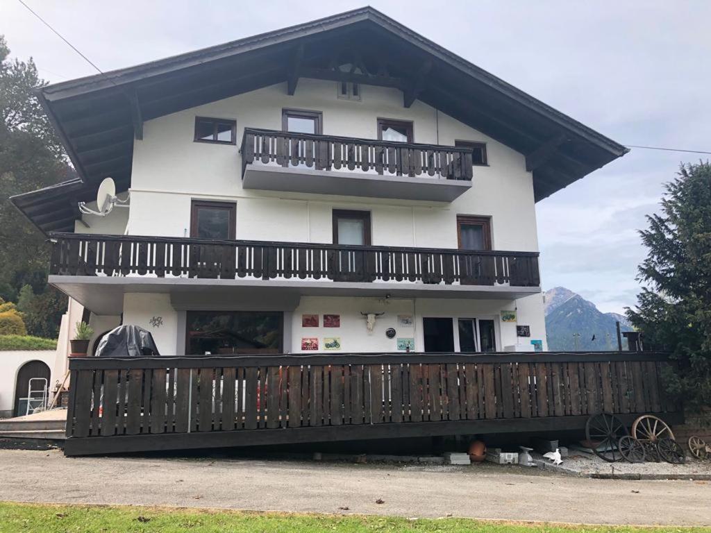 uma grande casa branca com uma varanda de madeira em Gästehaus Schmitt em Lähn