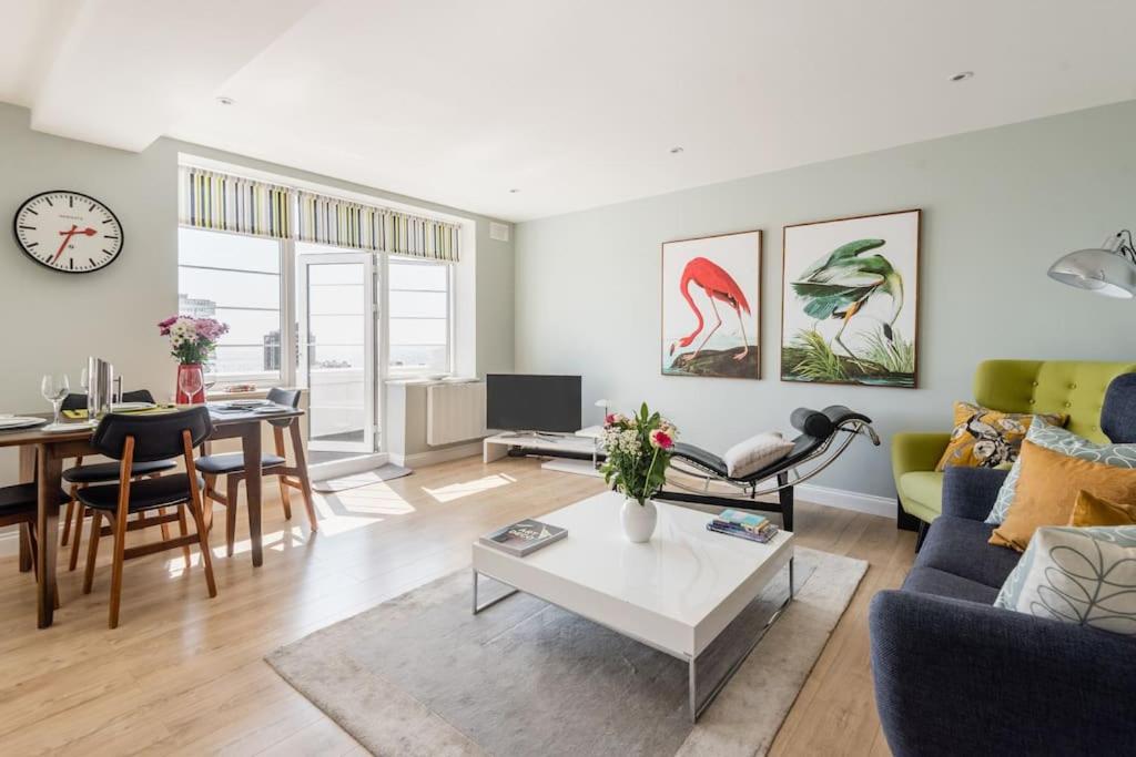 a living room with a couch and a table at Spacious and luxe two king bedroom sea-view apt in Brighton & Hove