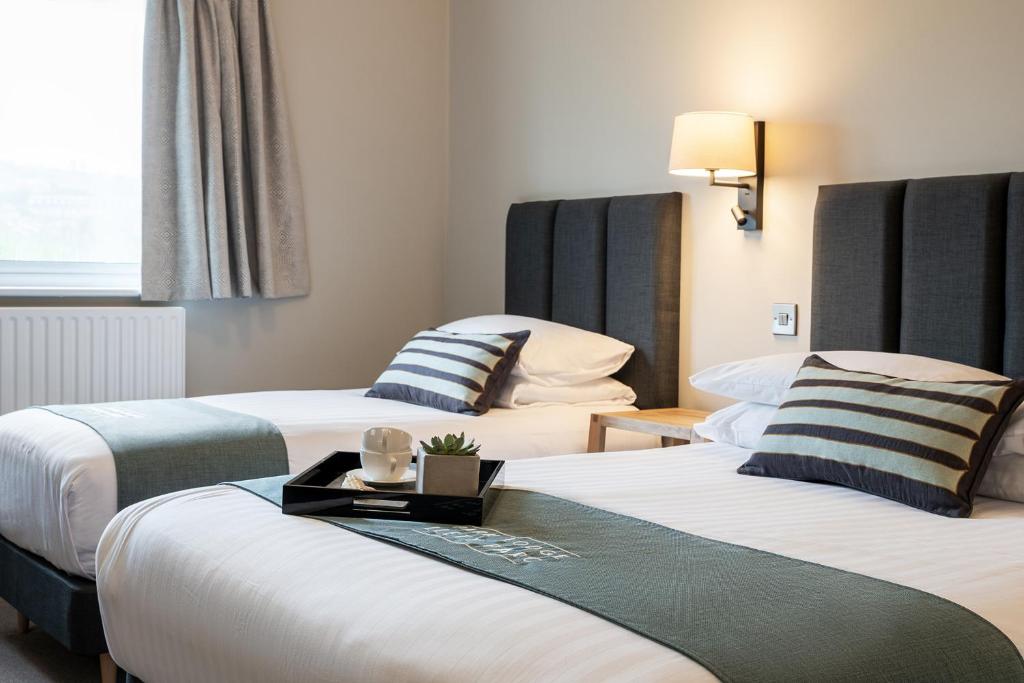 a hotel room with two beds with a tray on it at Aberystwyth Park Lodge Hotel in Aberystwyth