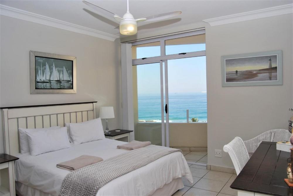 1 dormitorio con cama y vistas al océano en 53 Sea Lodge Umhlanga Rocks en Durban