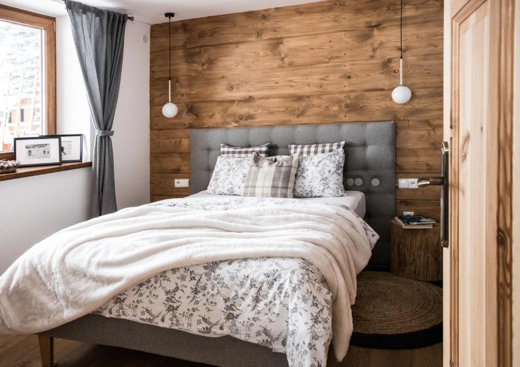 um quarto com uma cama e uma parede de madeira em Apartament Gorsky em Poronin