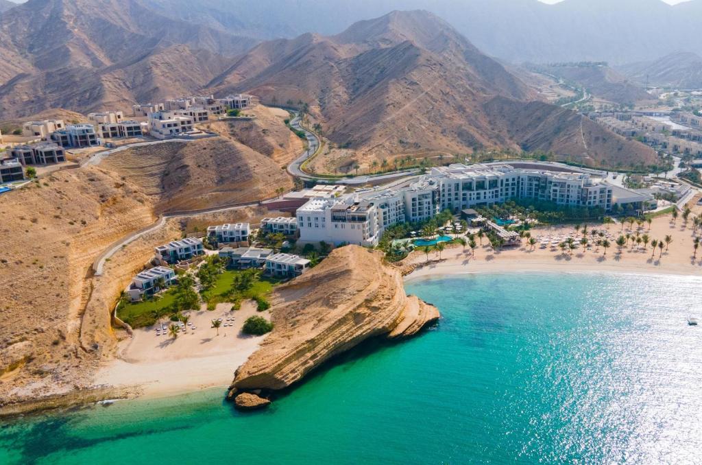 uma vista aérea de uma praia com pessoas e edifícios em Jumeirah Muscat Bay Oman em Mascate