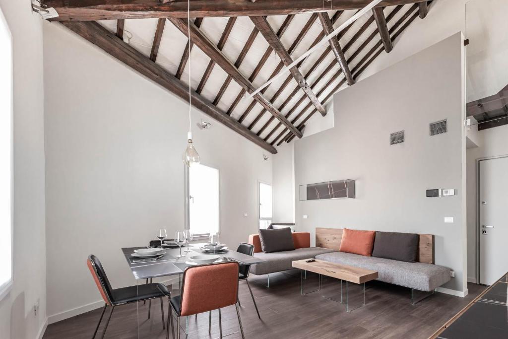 un soggiorno con divano e tavolo di Palazzo '900 Design Flats - Il Prato a Padova