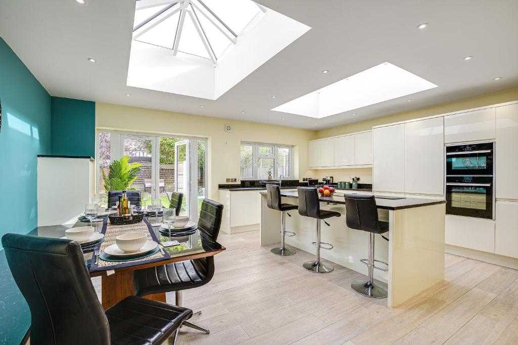 a kitchen with a dining room table and chairs at Ashford, Legoland, Windsor, Heathrow Serviced House in Stanwell