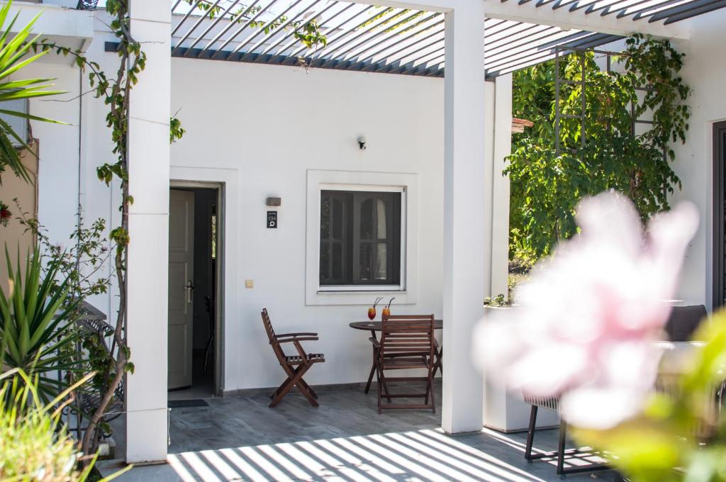 patio bianco con tavolo e sedie di Sunny Garden Hotel a Tsilivi