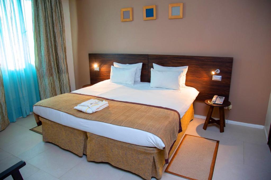 een slaapkamer met een groot bed in een hotelkamer bij Hotel La Villette in Antananarivo