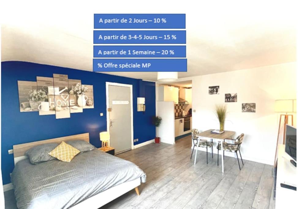 sypialnia z niebieską ścianą z łóżkiem i stołem w obiekcie Moissac Centre appartement indépendant calme cour Intérieure pour vélo 30m2 w mieście Moissac