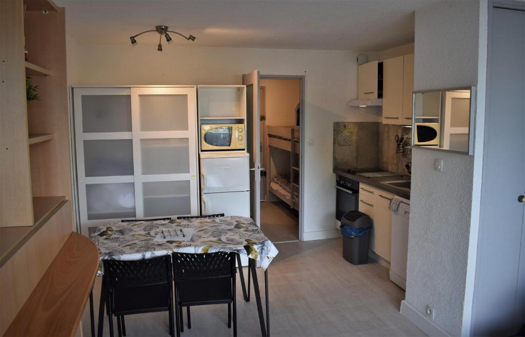 une petite cuisine avec une table et des chaises dans l'établissement studio cabine 100m plage, au Grau-du-Roi