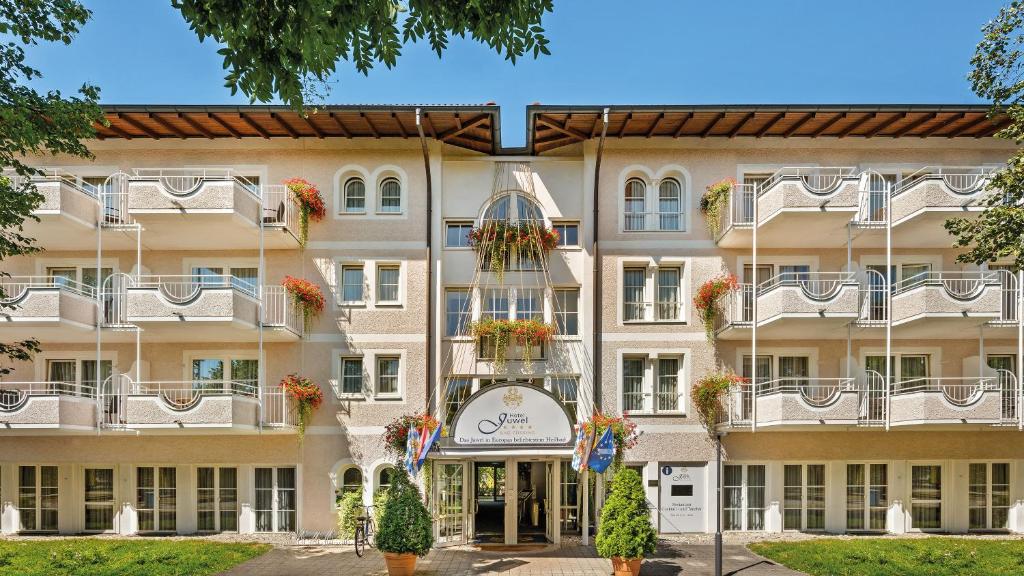 an exterior view of a large building with flowerpots at Hotel Juwel in Bad Füssing