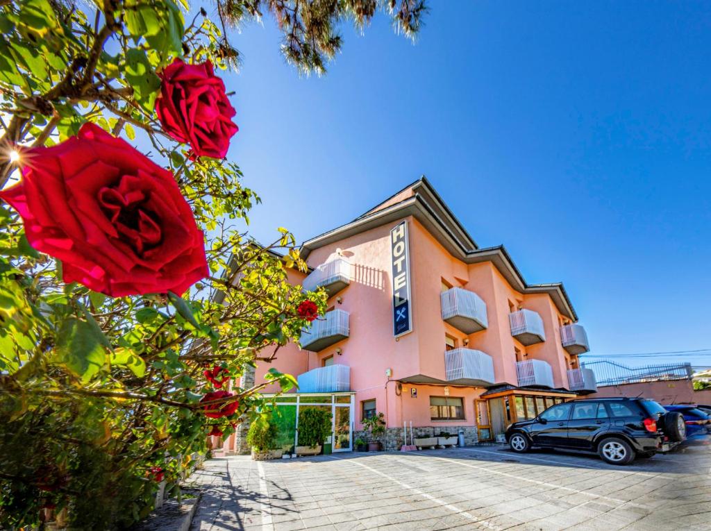 un edificio con una rosa roja delante de él en Hotel Restaurante La Glorieta, en La Seu d'Urgell