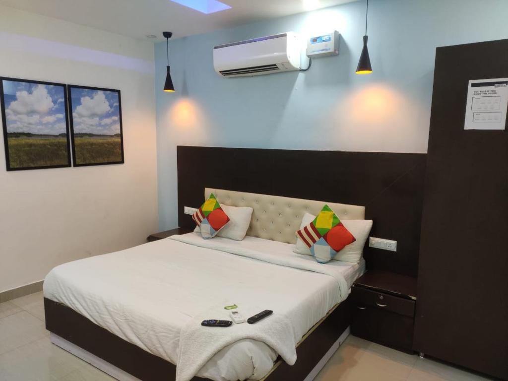 sypialnia z łóżkiem z białą pościelą i poduszkami w obiekcie Hotel APJ GRAND w mieście Faridabad