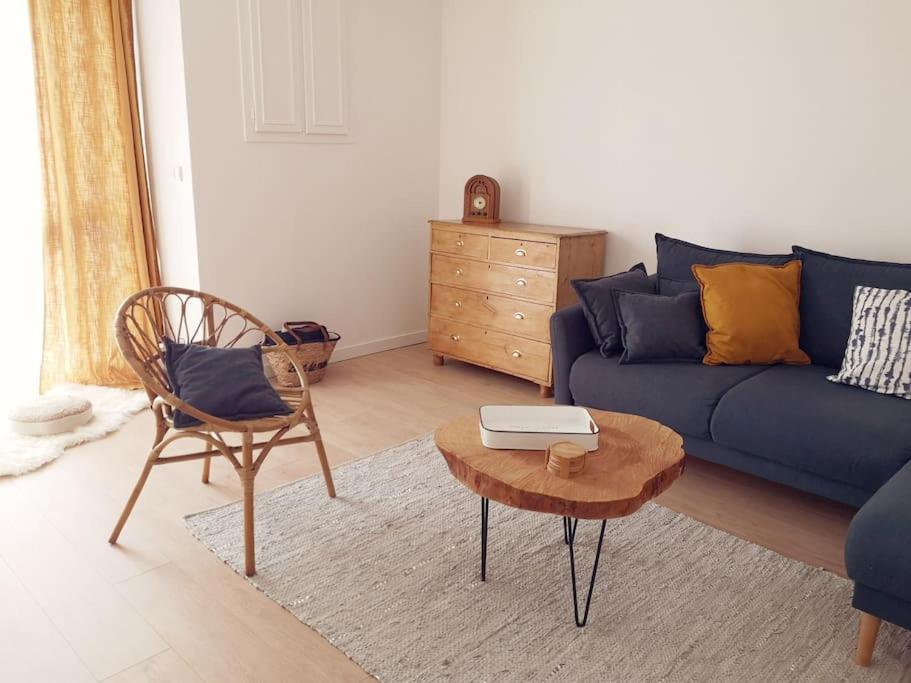 un salon avec un canapé bleu et une table dans l'établissement Maison 3,5km de la plage et proche Mont St Michel, à Saint-Broladre