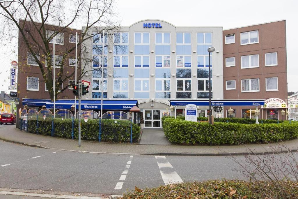 a building on the corner of a city street at Hotel am Berliner Platz in Langenfeld