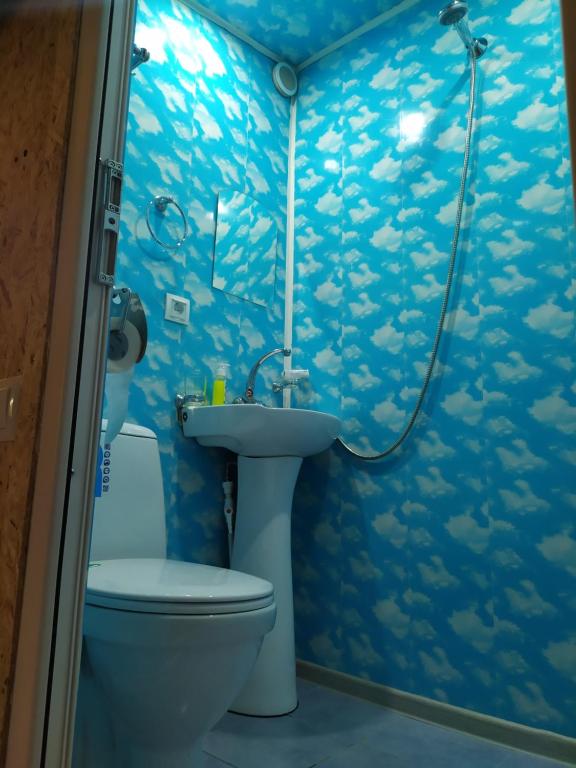 a blue bathroom with a toilet and a sink at COZY HOTEL SKS in Yerevan