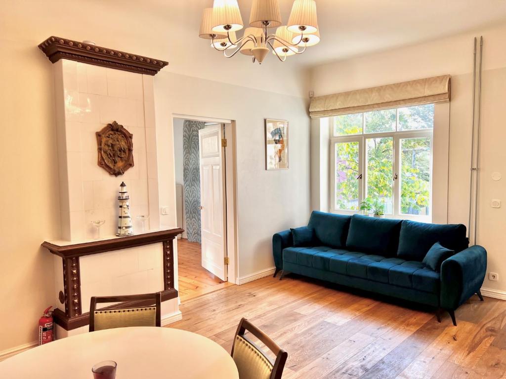 a living room with a blue couch and a table at Hubane ja ruumikas saunaga korter Pärnu kesklinnas in Pärnu