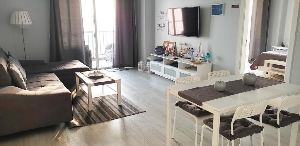 a living room with a couch and a table with chairs at Crepúsculo in Puerto de la Madera