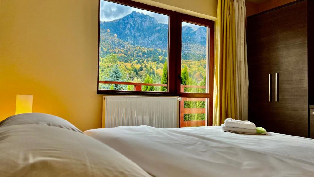 ein Schlafzimmer mit einem Bett und einem Fenster mit einem Berg in der Unterkunft AMK House - Busteni in Buşteni