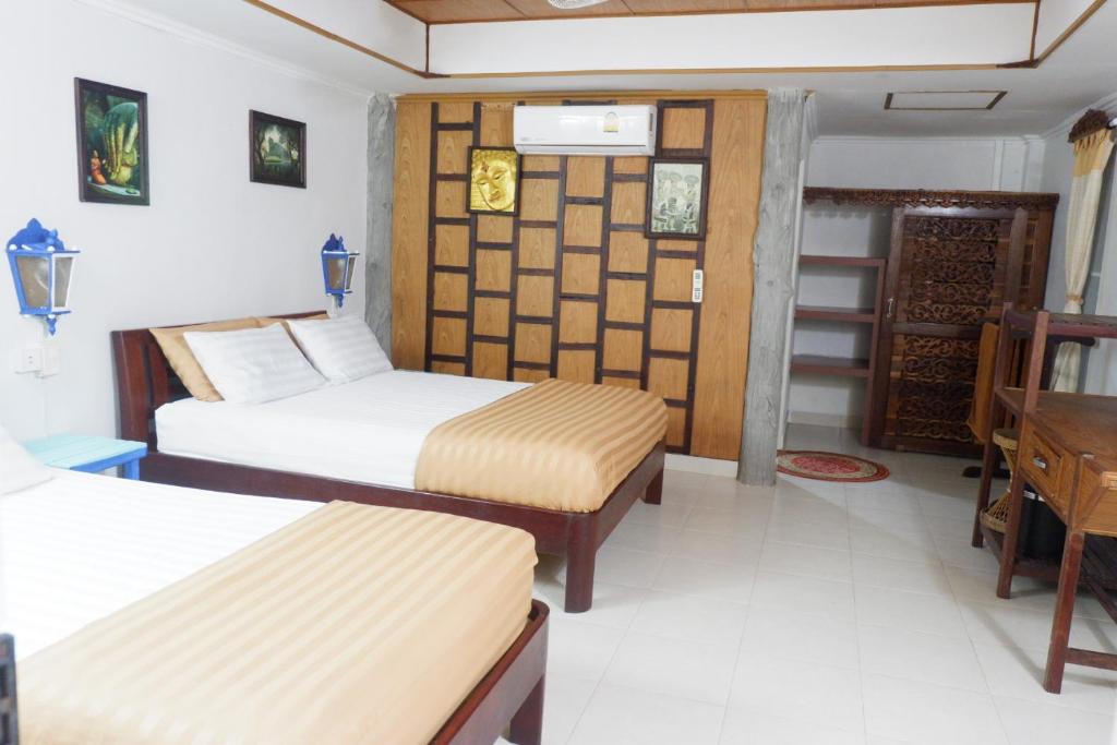 a hotel room with two beds and a desk at Bamboo Bungalows in Ko Phayam