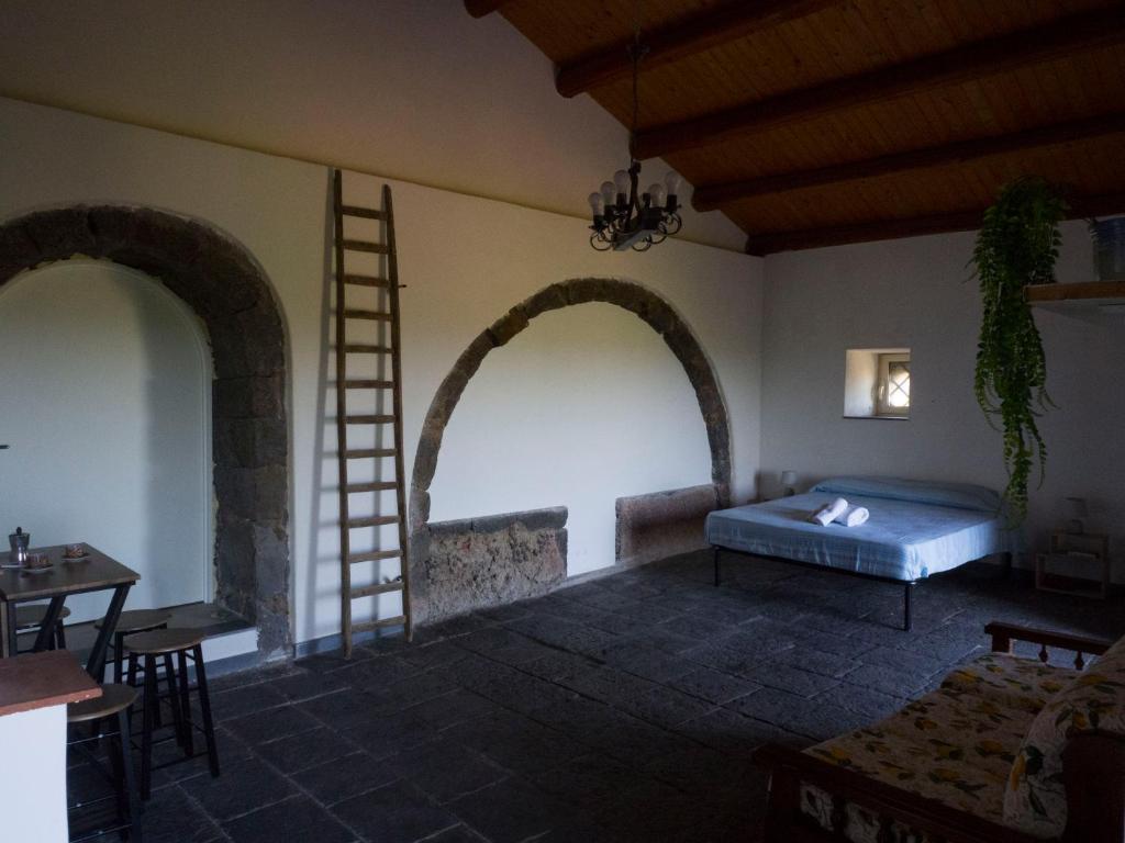 1 Schlafzimmer mit 2 Bögen und 1 Bett in einem Zimmer in der Unterkunft Il palmento di Beppe in Santa Tecla