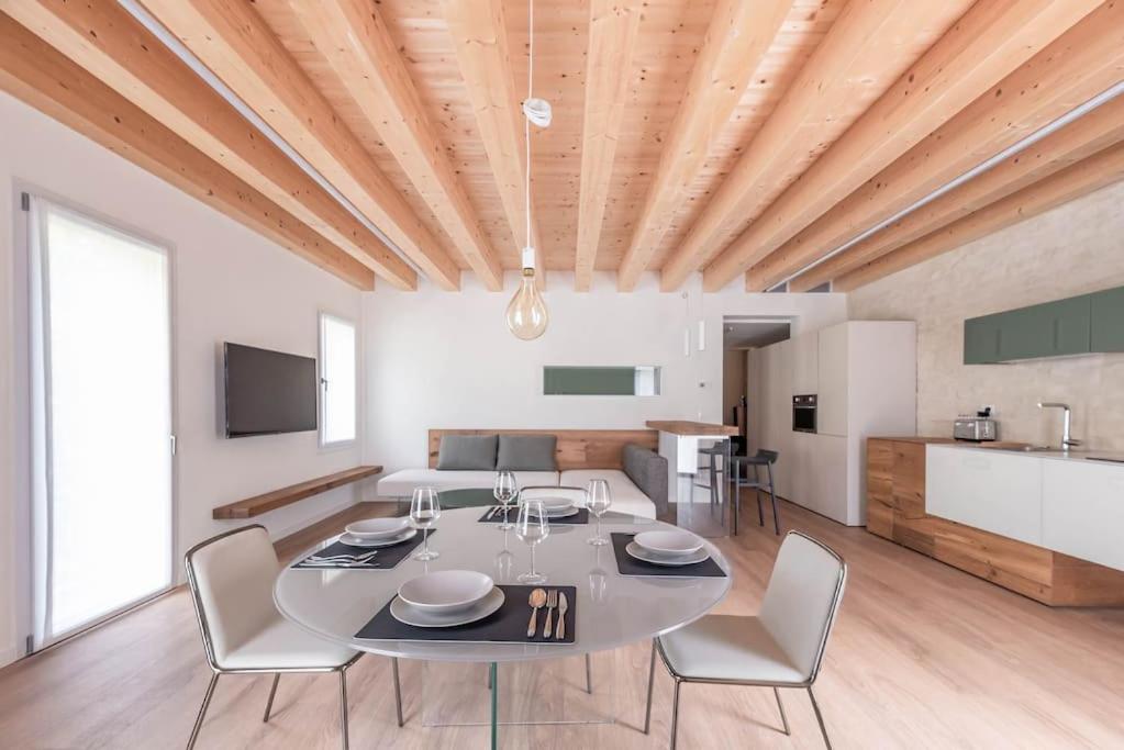 a dining room and kitchen with a table and chairs at Palazzo '900 Design Flats - Il Gran Salone in Padova